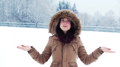 smiling woman in fur jacket enjoying the snowfall