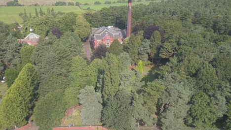 4k drone footage of a brick building in the forest. push in from wide