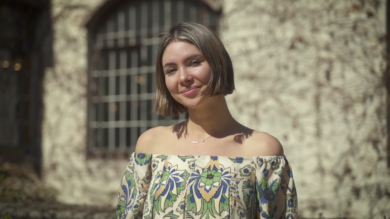 close-up tiro all'aperto di una bella giovane donna sorridente verso la telecamera