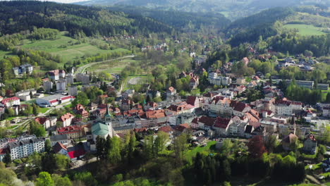 Aerial-view-of-old-European-town-located-among-forested-hills