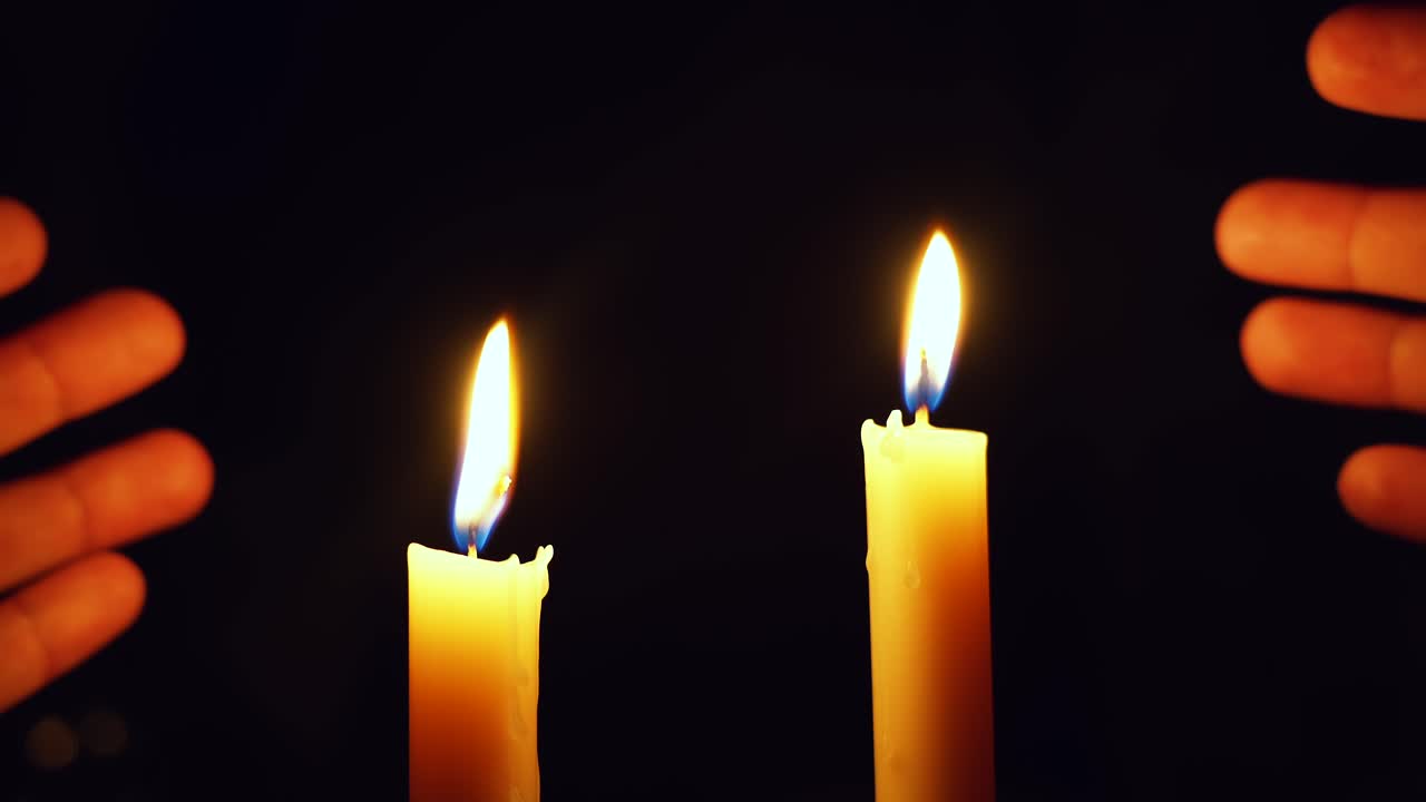 Due candele illuminano il buio dopo un blackout, bellissimi colori nell'oscurità