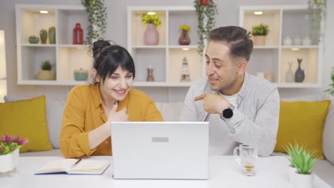 couple confirming what they see on laptop.