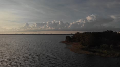 Luftdrohnen-Weitwinkelaufnahme,-Die-Auf-Das-Wasser-Des-Jachthafen-Bootsanlegers-Mit-Leuchtturm-An-Den-Palmen-Der-Bucht-Schwenkt