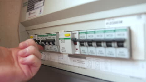 a man resets a tripped fuse in a power circuit breaker electricity fuses box