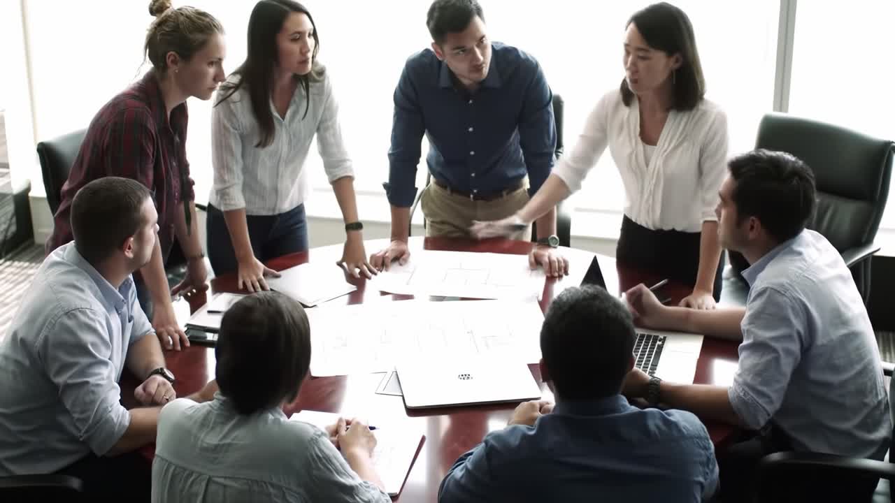 Collaborative Team Meeting in a Conference Room: Engaged Participants Discussing Project Plans and Analyzing Documents Around a Conference Table