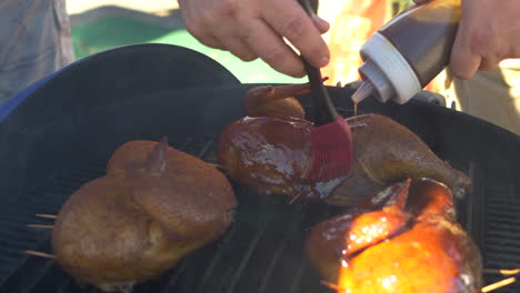 Ein-Mann-Streicht-Während-Eines-Grillwettbewerbs-BBQ-Sauce-Auf-Hühnchen