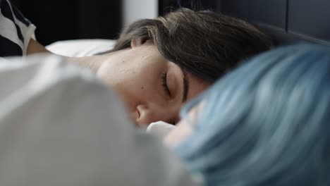 un video en primer plano de una pareja de lesbianas durmiendo en la cama.