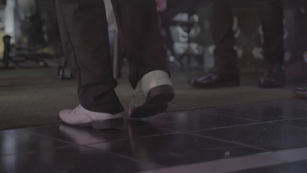 스튜디오에서 전통적인 볼리비아 민속 춤을 추는 남자의 낮은 각도를 닫습니다