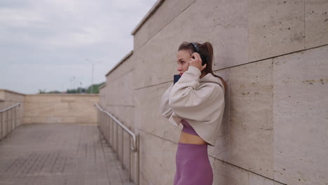 woman outdoors listening to music and using phone