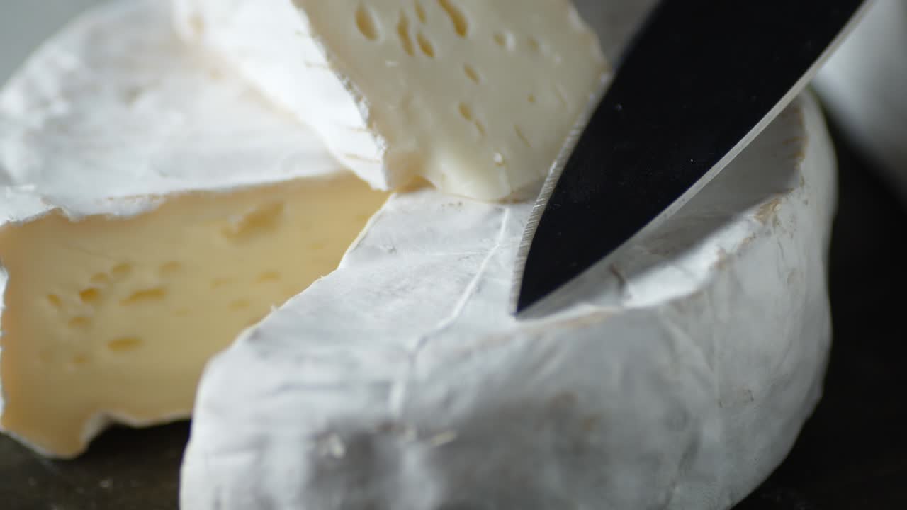 Camembert cheese with knife rotates slowly.