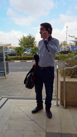 businessman using smartphone on office building steps