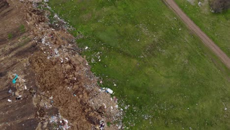 environmental pollution - plastic bottles, bags and trash in green field - aerial shot