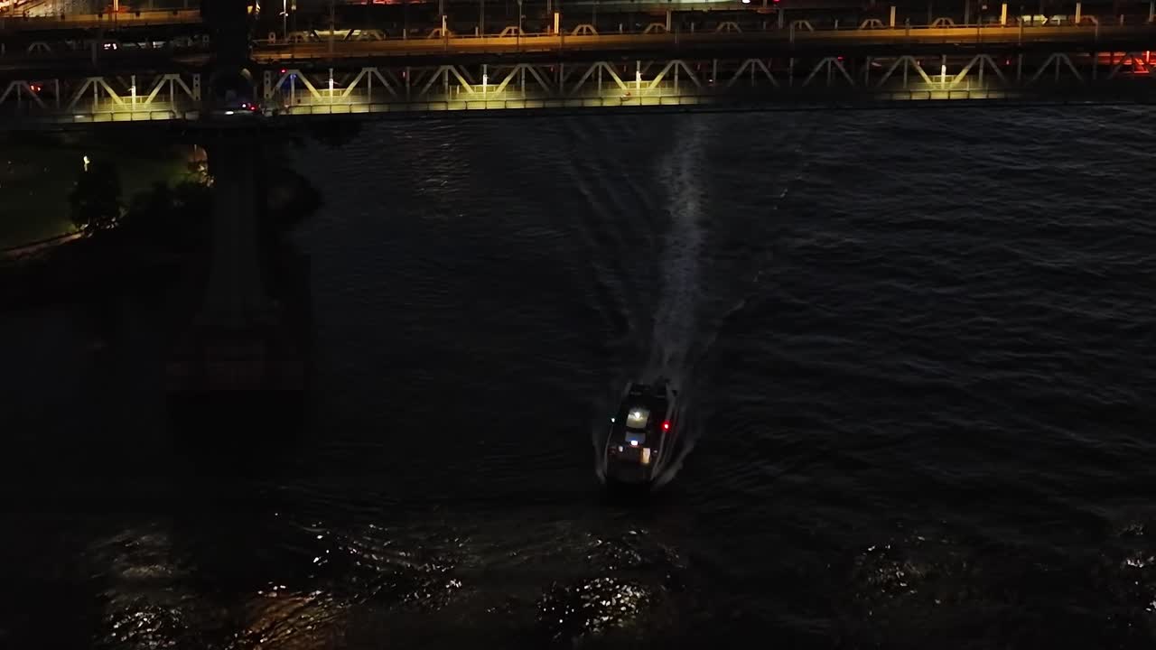 Scenic aerial view of a boat navigating under a bridge in New York City