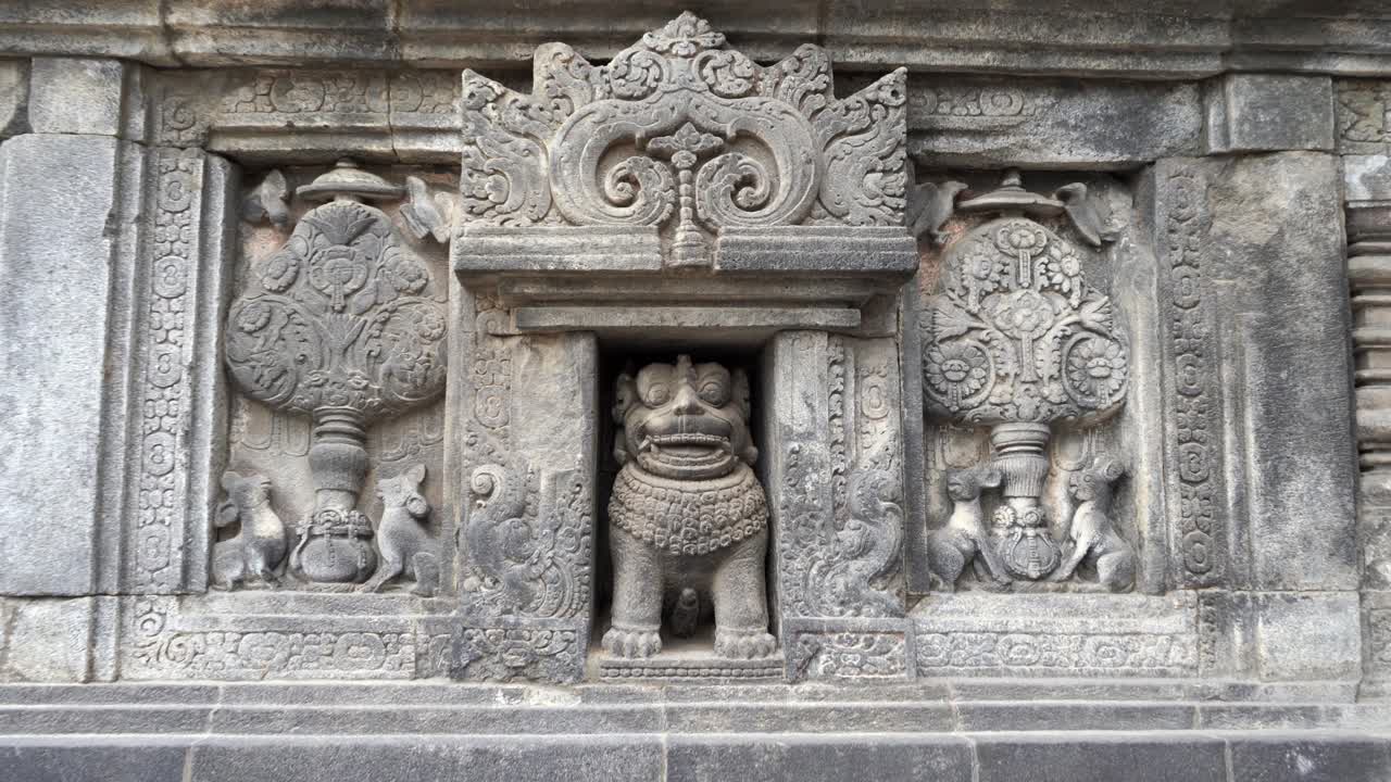 Indonesia,Prambanan Temple, wall relief in details,rats,rabbits,birds and the Chinese lion in the middle. Beautiful ancient stone art, flowers and symbols, camera zooms in slowly