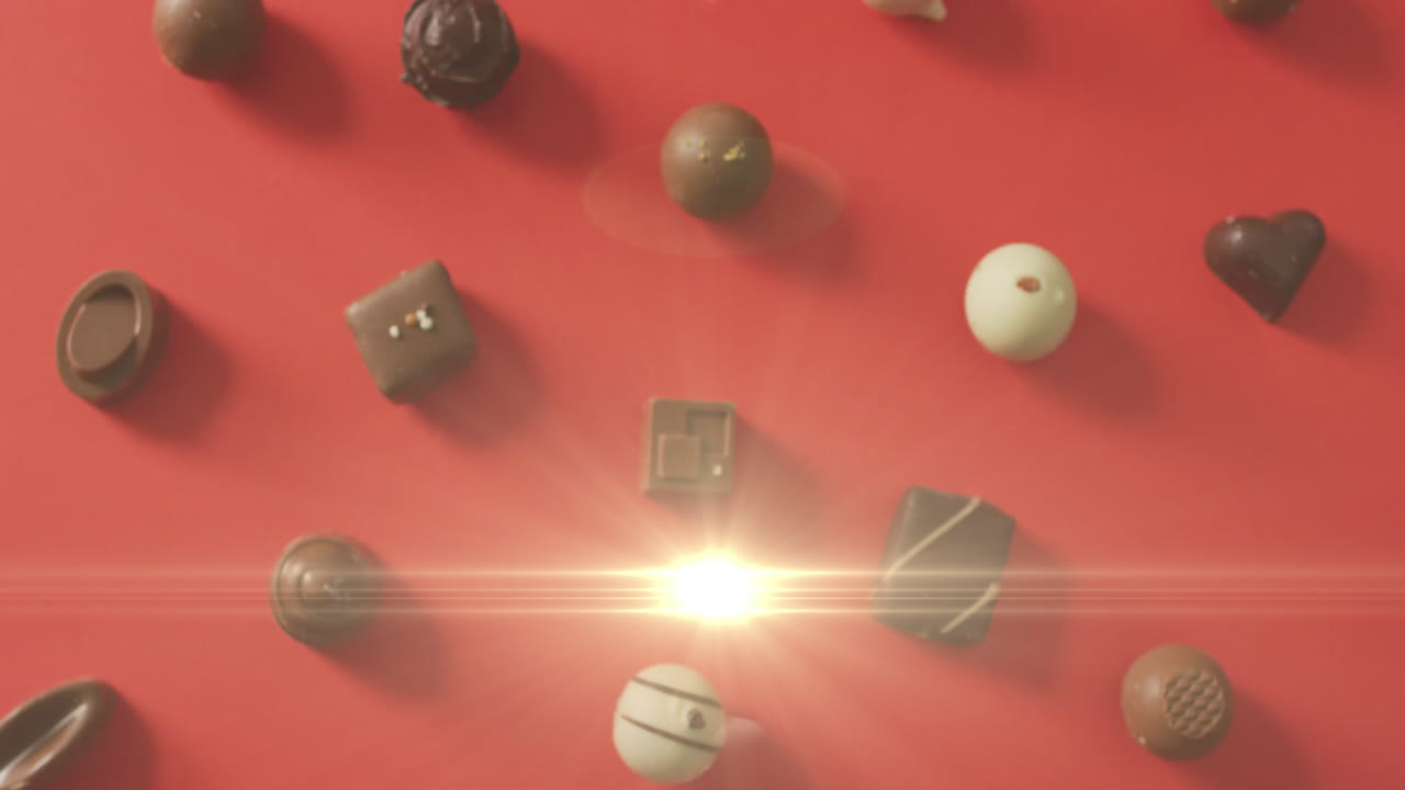 animación de la luz sobre pralinas de chocolate en superficie roja