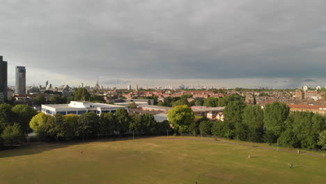 AERIAL-DOLLY-OUT:-Drone-zooming-out-with-a-spctacular-view-of-London-City-from-Wandsworth-Park,-London-UK