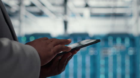 vertical video close up of admin in data center workplace using tablet