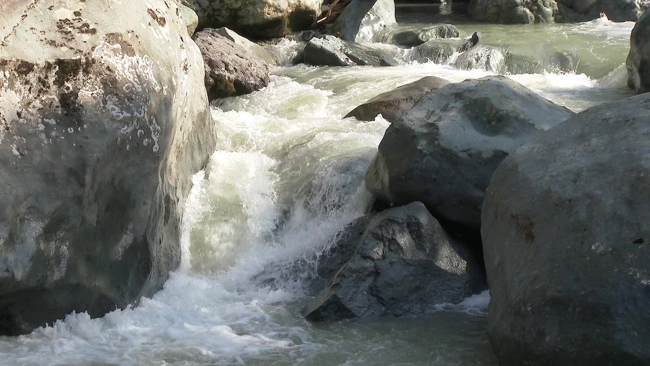 Acqua impetuosa di fiume di montagna che si riversa sulle rocce