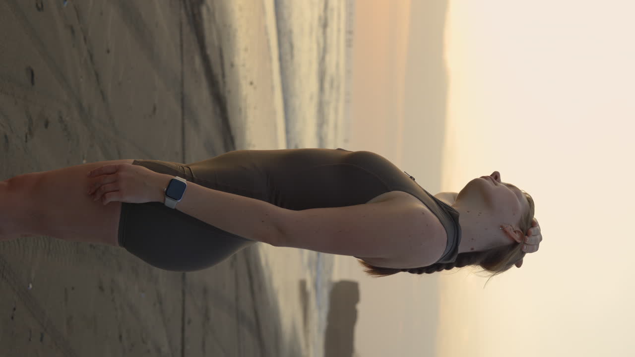 Woman in swimsuit on beach at sunset