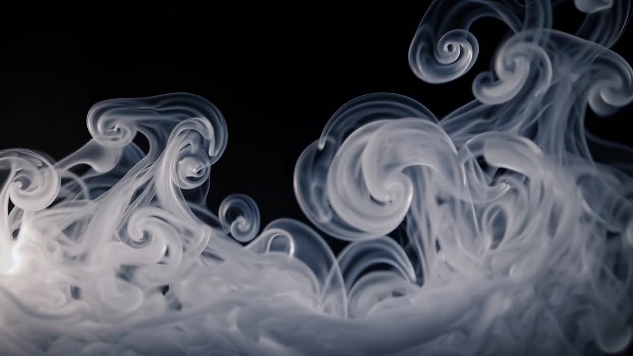 Abstract video of swirling white smoke against a black background, captured from a low-angle