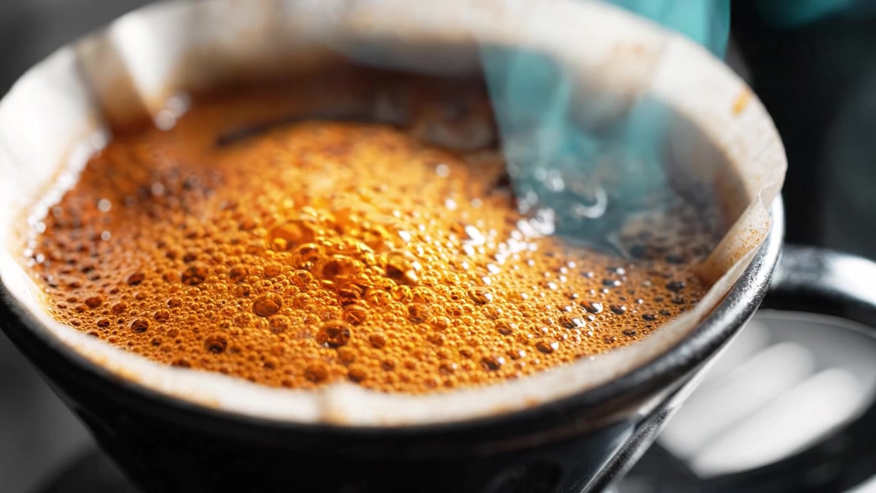 Brewing Coffee: The Process of Pouring Hot Water Over Ground Beans in a Filter to Create Rich Aromatic Brew - A Close-Up Perspective of Steaming Liquid
