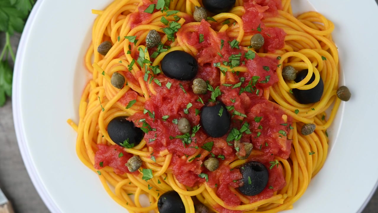 Pasta alla puttanesca italiana con salsa di pomodoro, capperi e olive nere