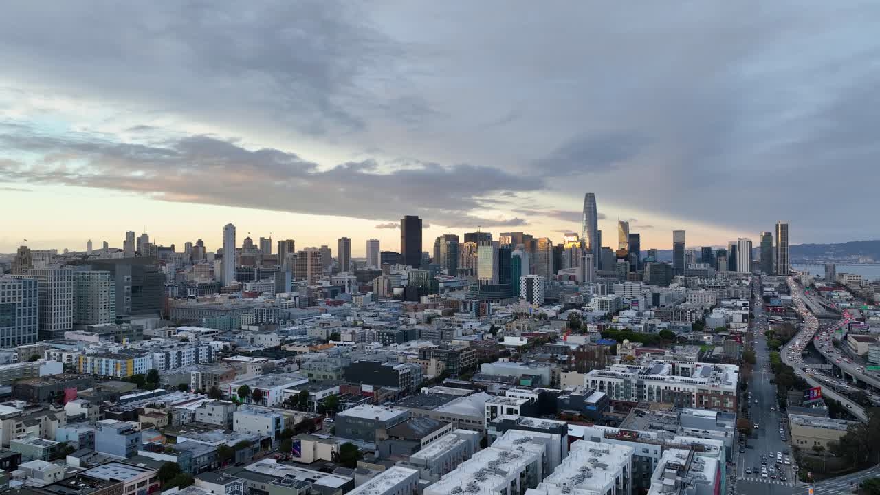 Rising aerial over residential neighborhood with San Francisco skyline at sunset