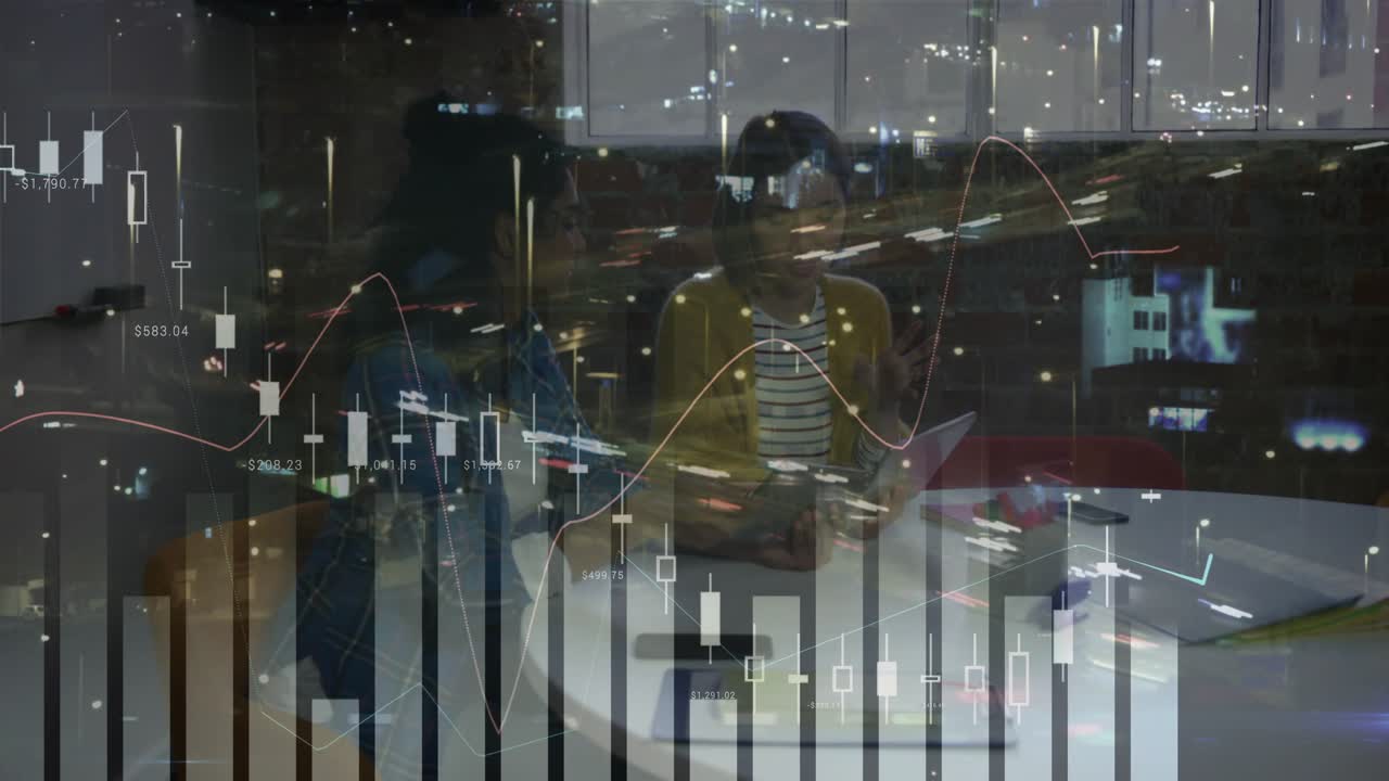 Denim jacketed woman scrolling laptop as yellow cardigan woman highlighting business chart analysis