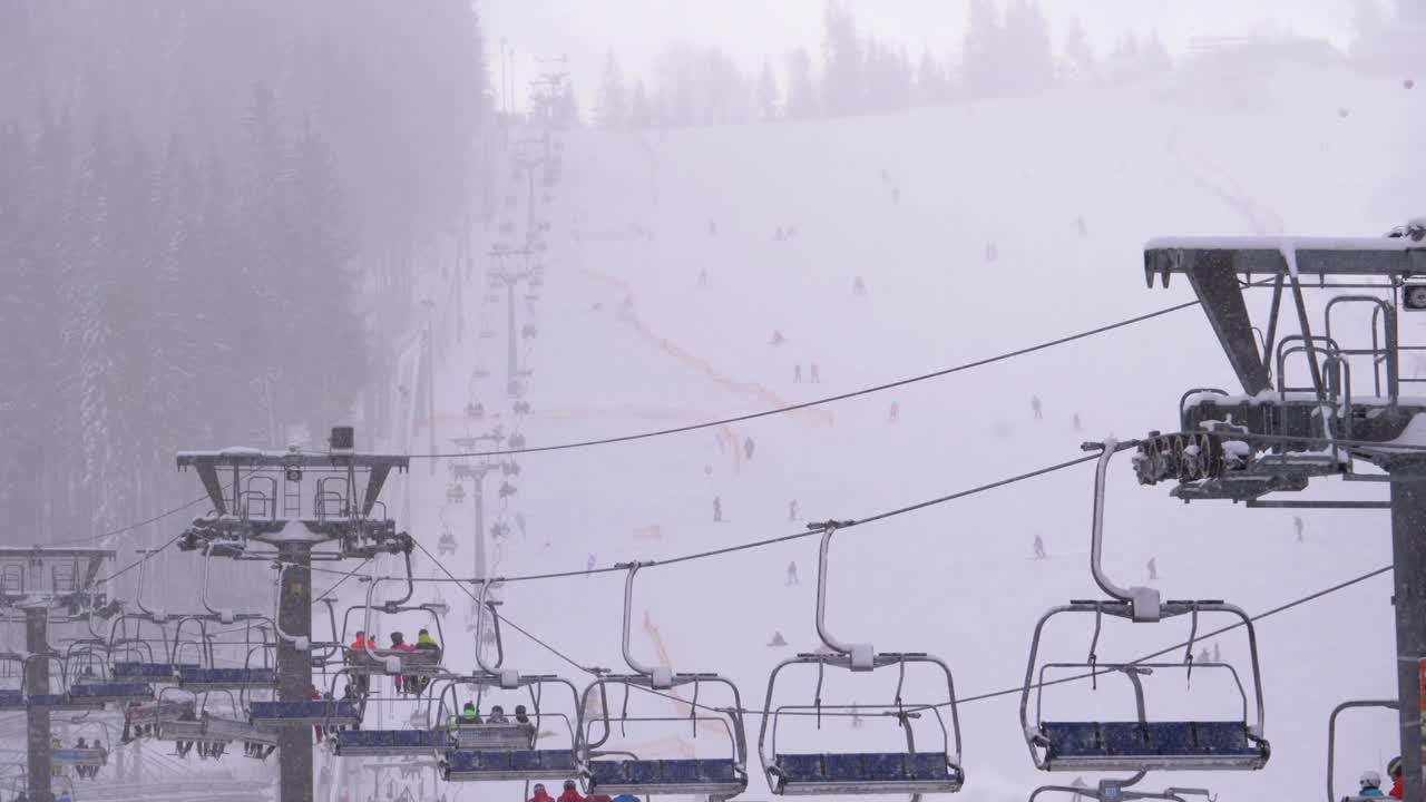 스키 리조트에서 스키 리프트. 스키 선수들은 스키 의자 엘리베이터를 타고 눈이 내리는 스키 경사까지 올라갑니다.