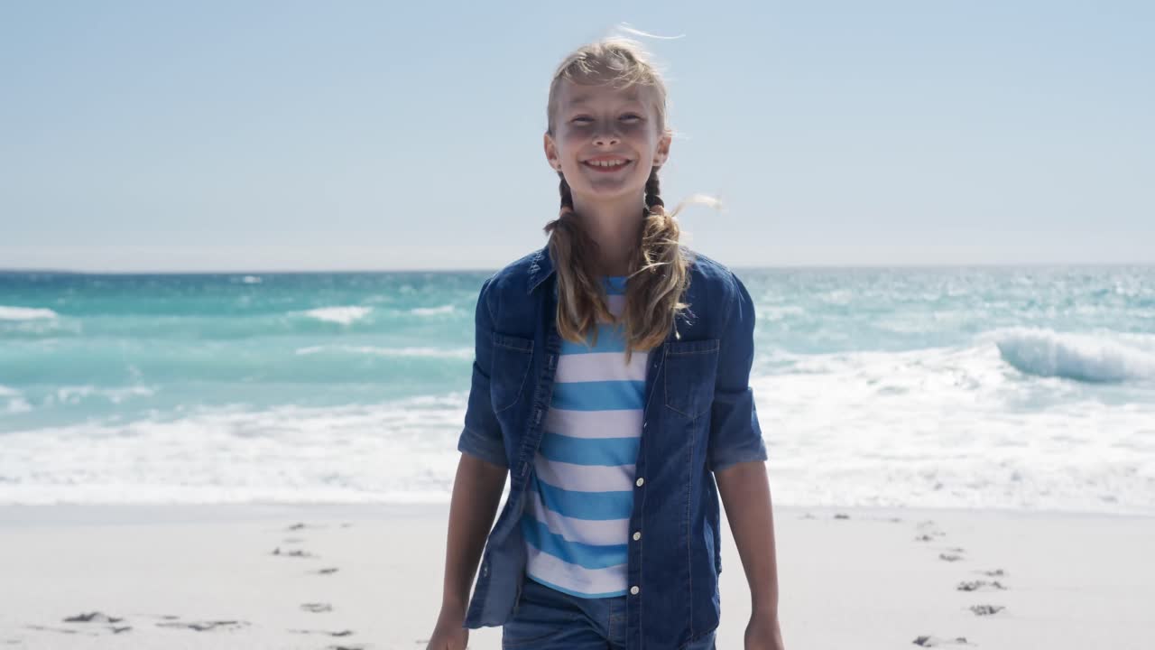 chica de pie en la playa y mirando a la cámara