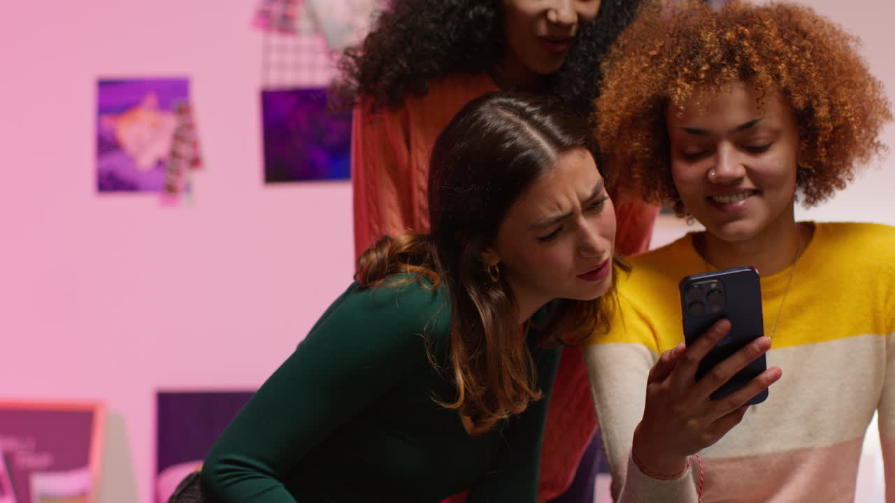 tres amigos reaccionan a algo en un teléfono