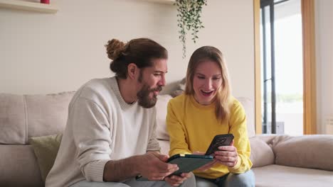 couple using technology on couch