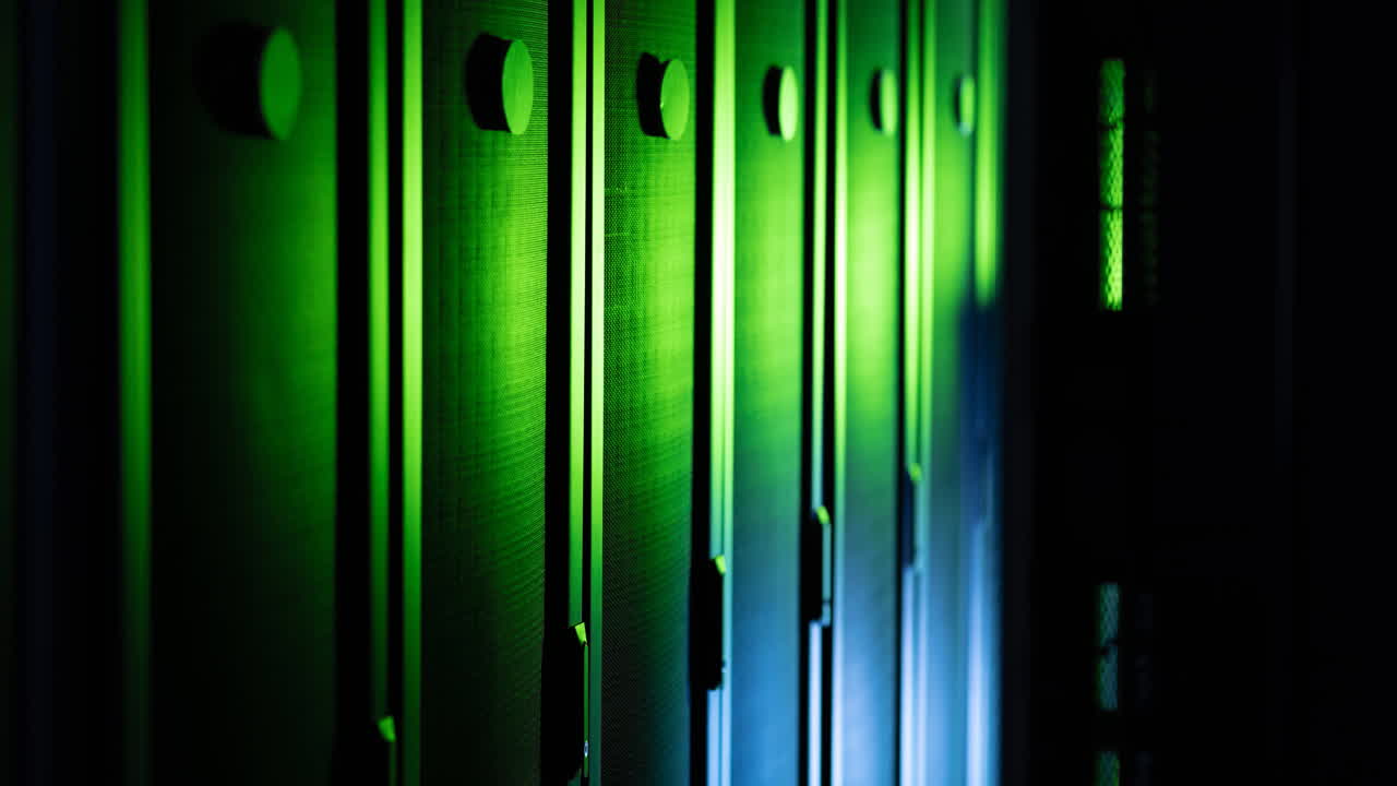 Video of close up of empty corridor with row of blue and green computer servers