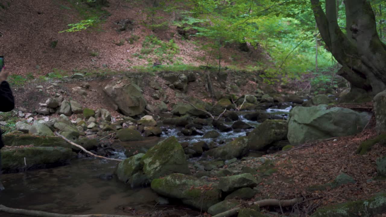 Hiking trail through lush forest leading to Sutovsky waterfall in Mala Fatra, Slovakia. Aerial view of small waterfall along the path. Scenic nature, perfect for travel and outdoor adventure themes