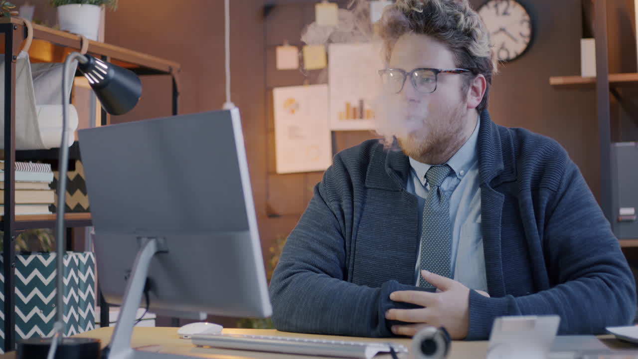 Man Smoking While Working at a Computer