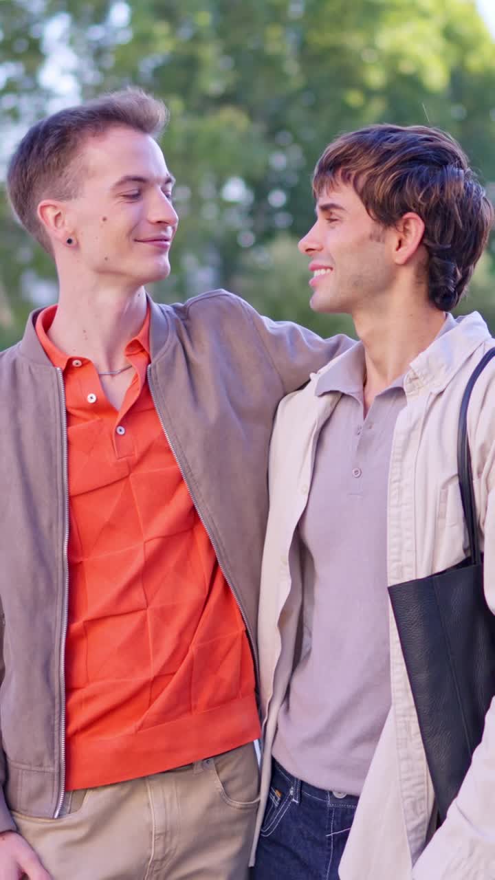 Giovane coppia gay felice che si abbraccia e sorride all'aperto