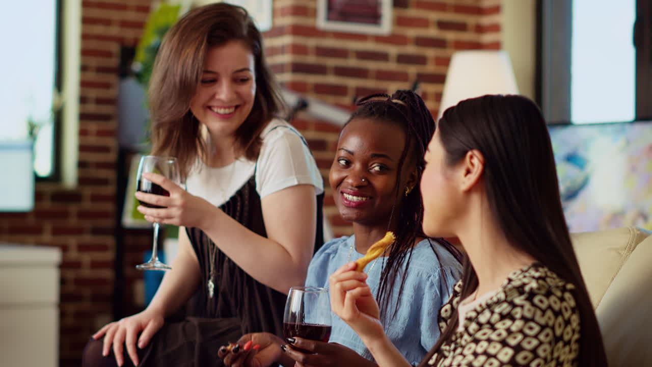 Multiethnic friends drinking alcohol and chatting in brick wall home