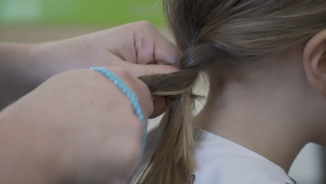 mother braiding a little girl's hair, close-up