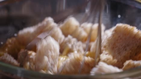 Mixing-Bread-Cubes-And-Fresh-Eggs-In-A-Bowl-Using-Whisk