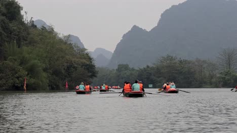 tourists rowing boats through scenic mountains