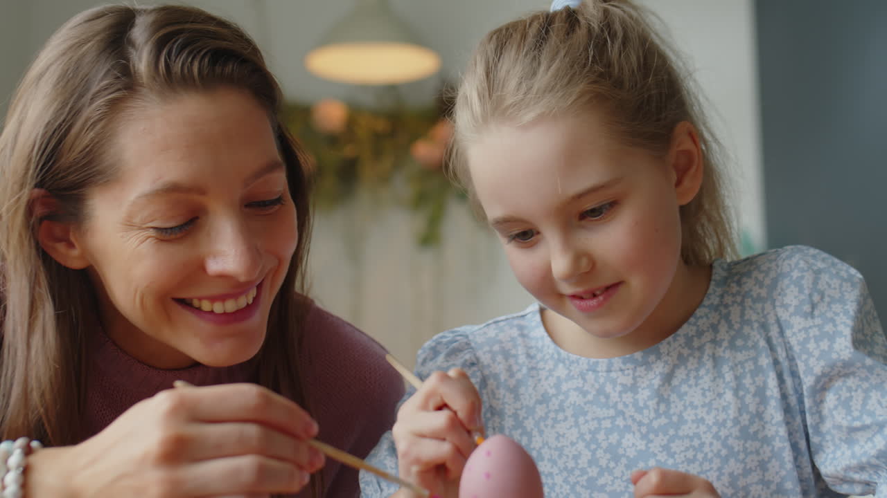 Mamma e figlia che dipingono puntini sulle uova di Pasqua
