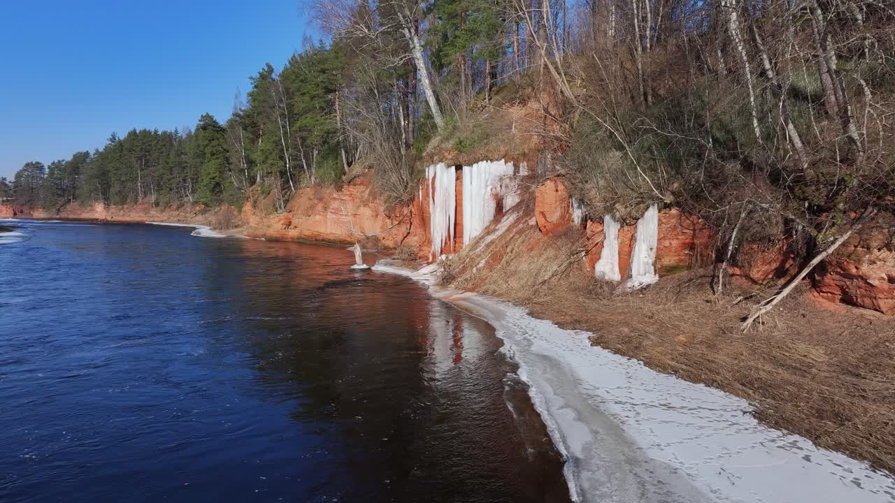 Sandstone cliffs with a icefall by the Salaca River in Latvia