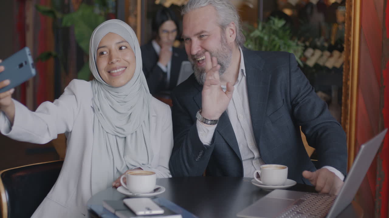 Business colleagues taking a selfie in a cafe