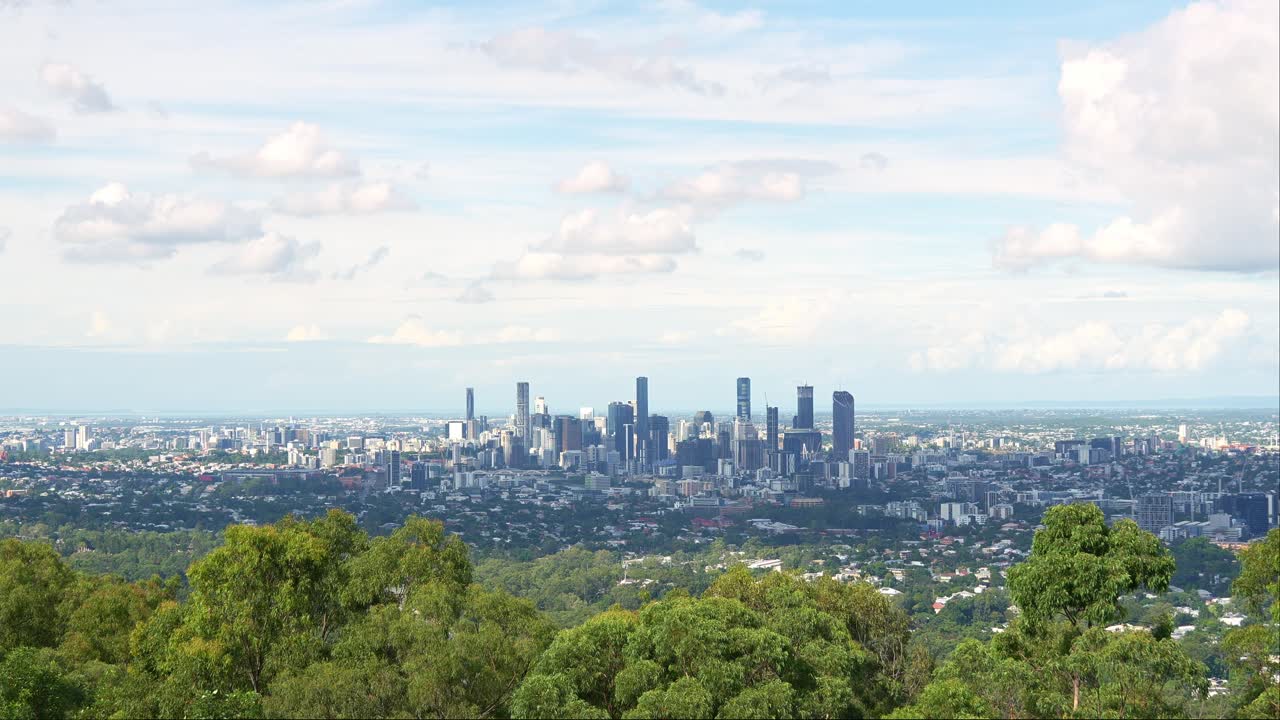 Panoramic City Skyline View with Green Trees and Cloudy Sky