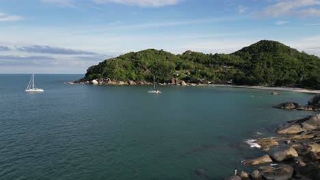 Statische-Aufnahme-Eines-Strandes-In-Den-Inselgruppen-Von-Koh-Samui-Mit-Stillstehenden-Booten-Und-Yachten-In-Der-Nähe-Des-Grünen-Hügels-Im-Wasser