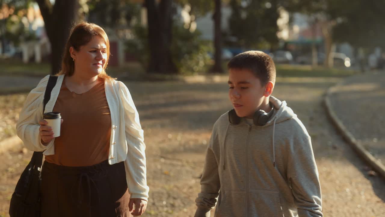 Mother and Son Walking and Talking in a Park