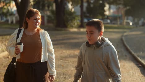 mother and son walking and talking in a park