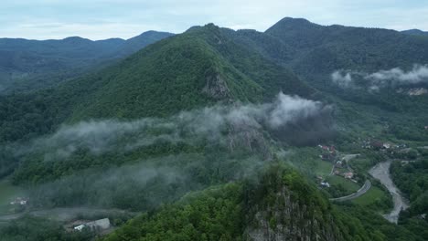 nubes de niebla delgadas sobre montañas boscosas cerca de la aldea rural de lepsa, condado de vrancea, rumania