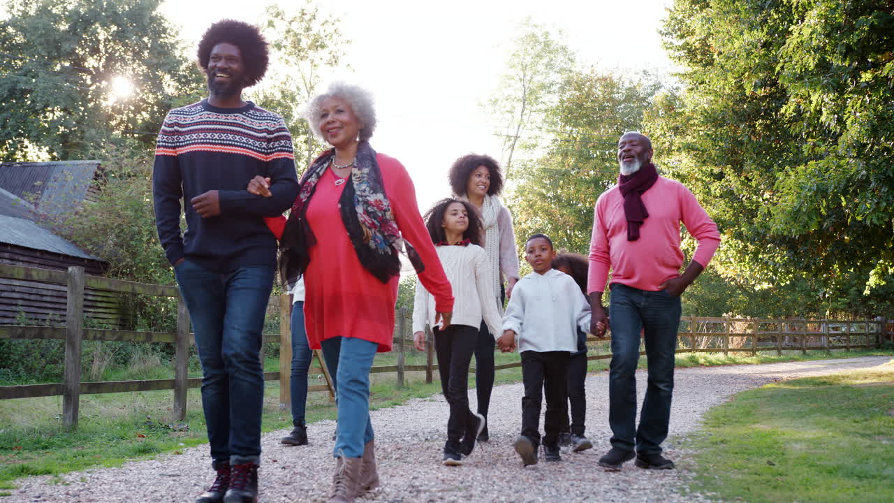 Tiefwinkelaufnahme einer Mehrgenerationenfamilie beim gemeinsamen Herbstspaziergang auf dem Land.