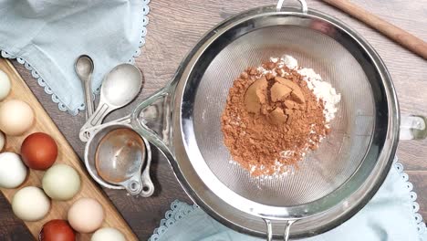 baking delicious caramel pecan brownies. in a mixing bowl with a flour sifter adding flour, salt and cocoa powder. freshly baked gooey chocolate brownies with sweet caramel and nutty pecans.